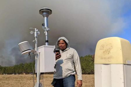 Dr. Marcus Williams seen here observing PM2.5 concentration levels on a small handheld measurement device.